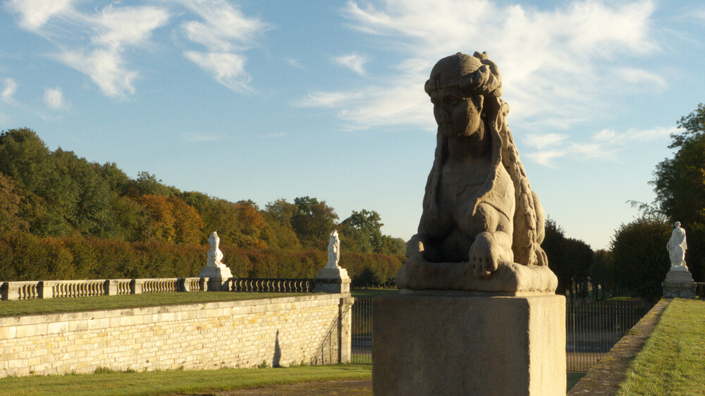 Uma das quatro esfinges que guardam o portão entre o Grande Canal e a Grande Platéia. — Castelo de Fontainebleau —